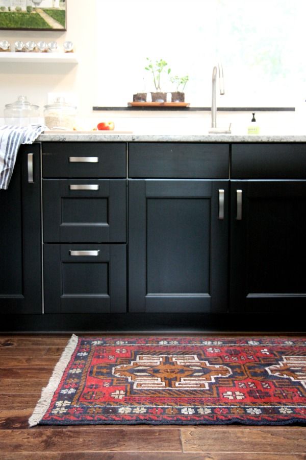 Black kitchen cabinets with colorful rug