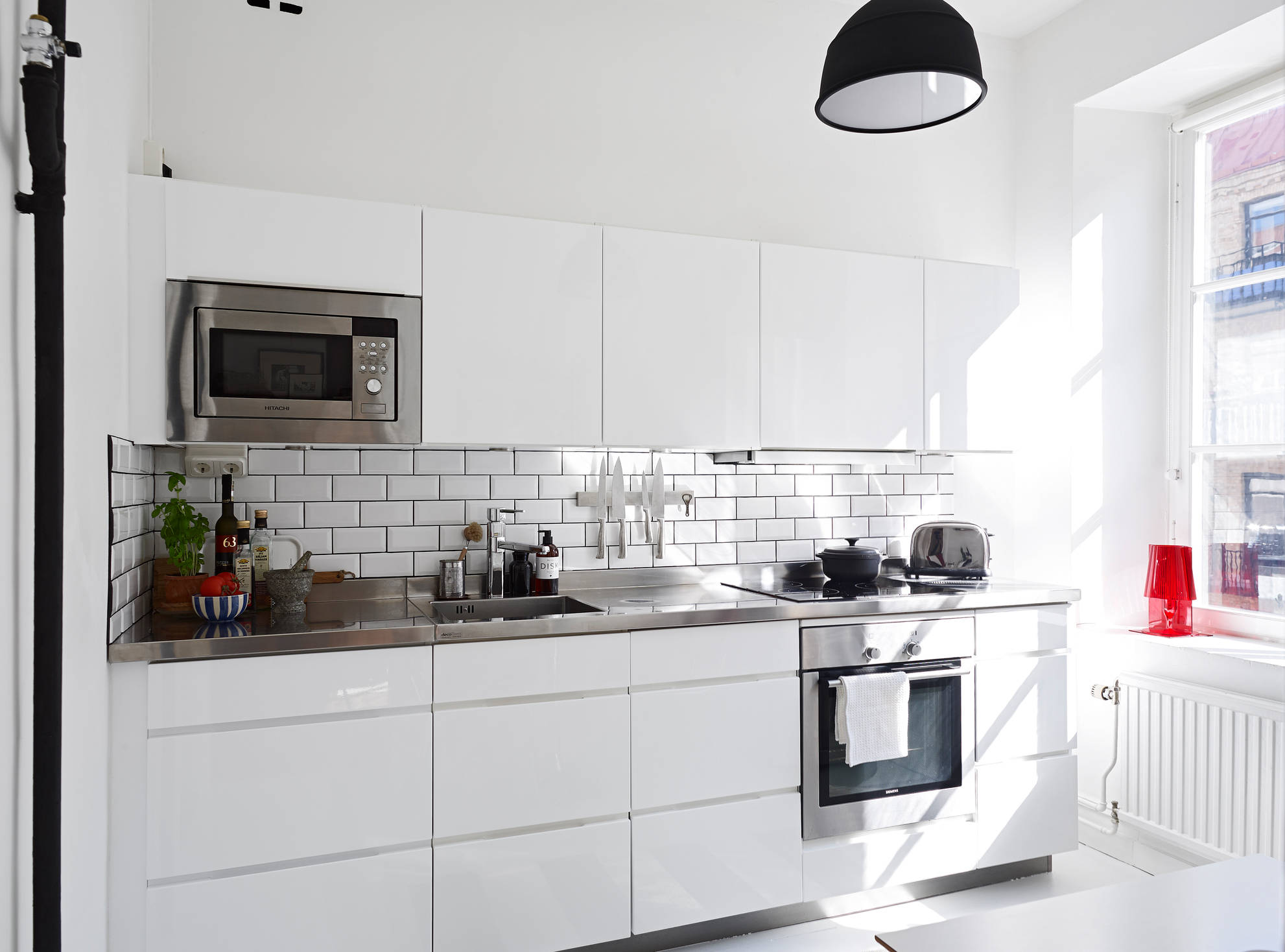 Black pendant light subway tiles stainless steel countertop