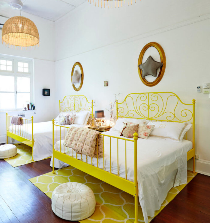 Childrens room with yellow double beds and decorative stars on the wall