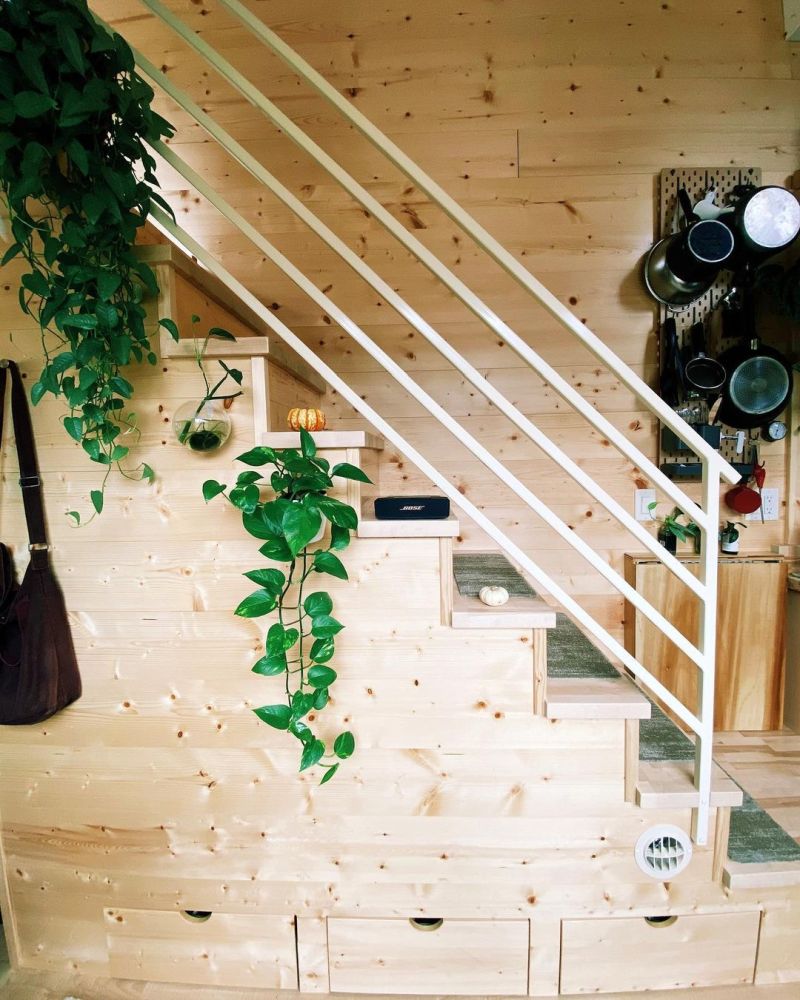 The staircase has built-in storage drawers and a coat rack to complement the entryway