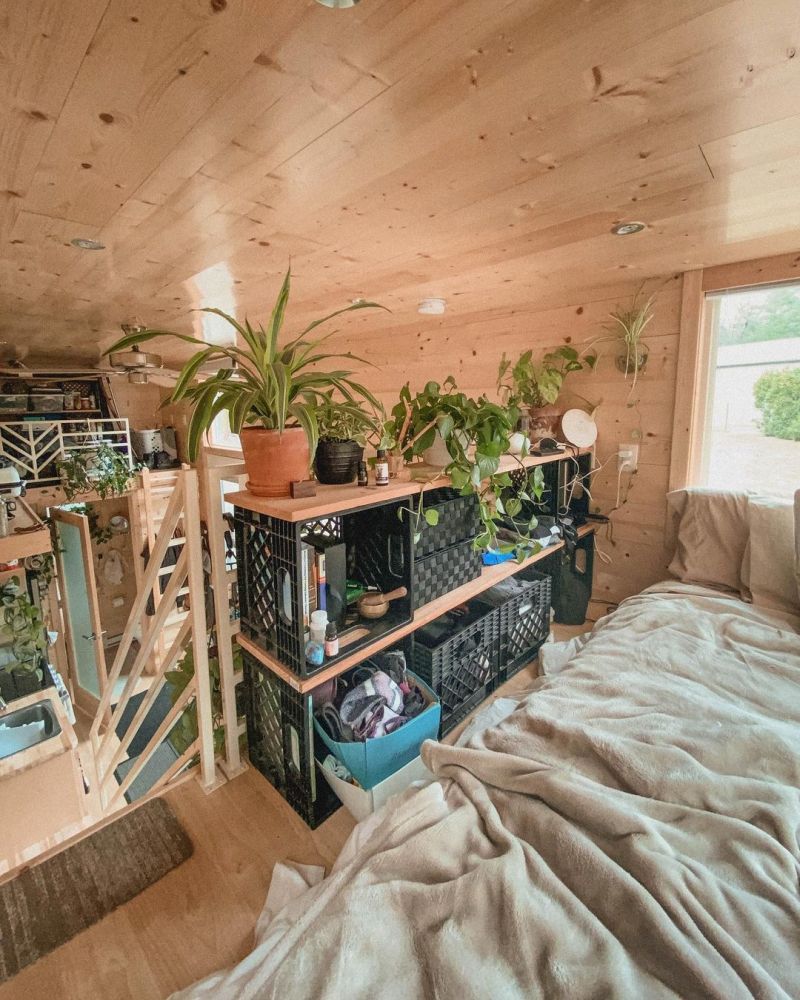 The sleeping area has a small closet made out of repurposed crates and wood planks