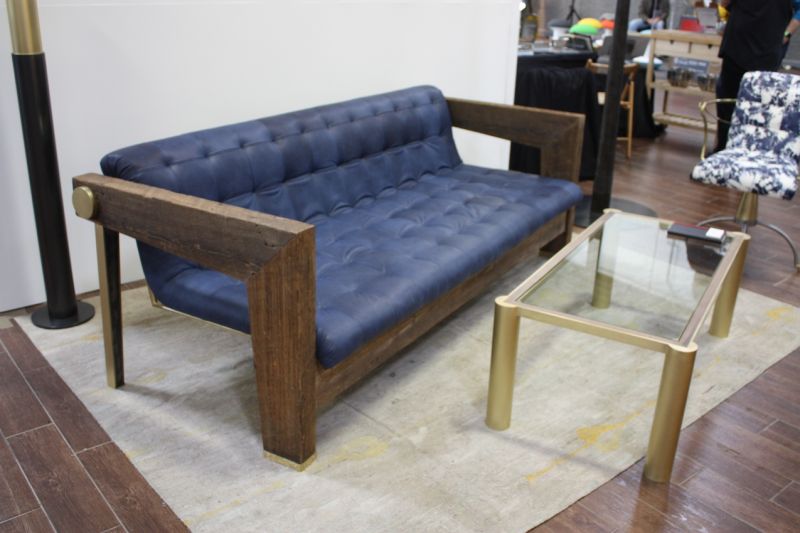 This grouping is by Cam Crockford Furniture and Fabrication. Crockford broke out on his own In 2013 when he founded Cam Crockford Design and opened his studio in the Brooklyn Navy Yard. All the pieces here feature unique details like the tapered legs on the back of the sofa and the large brass round at the top joint, and interesting corner features on the glass-topped table.