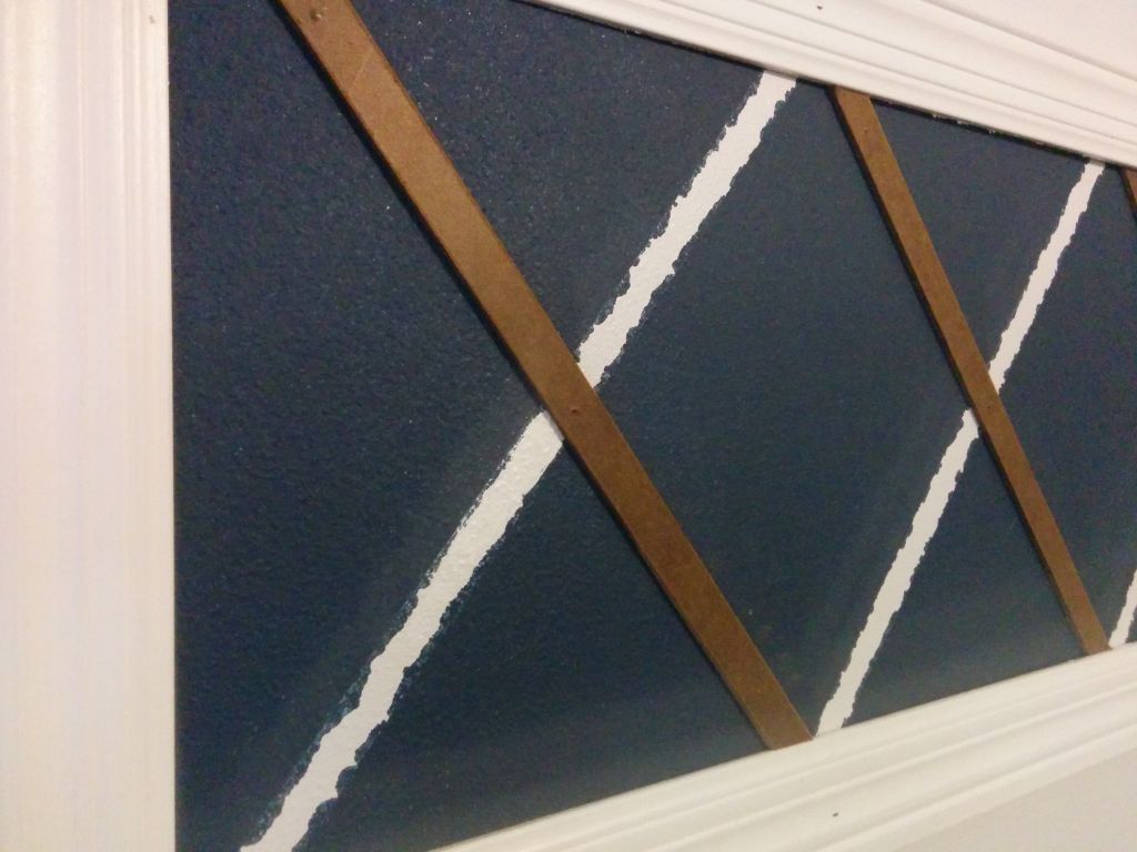 Installing wood detail x on wall 2