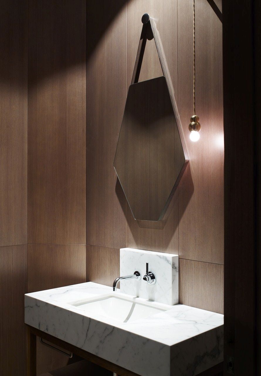 Marble vanity bathrom and wood paneling walls