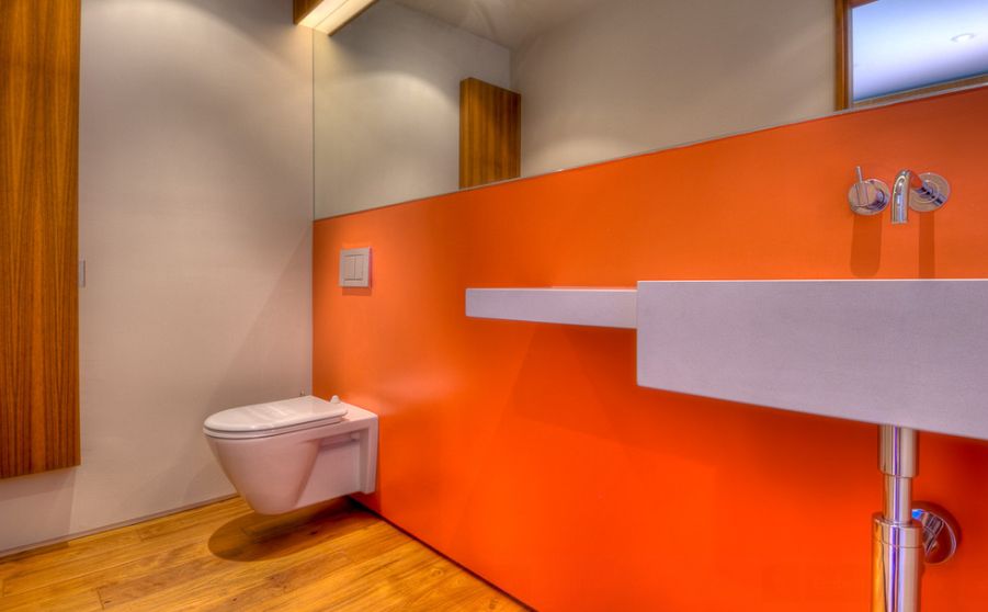 Orange bathroom wall floating toilet