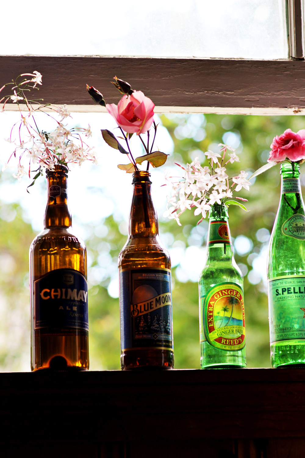 recycled old bottles as a single flower vase