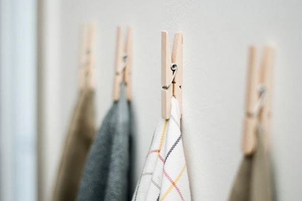 Use clothes pins to hang kitchen towels