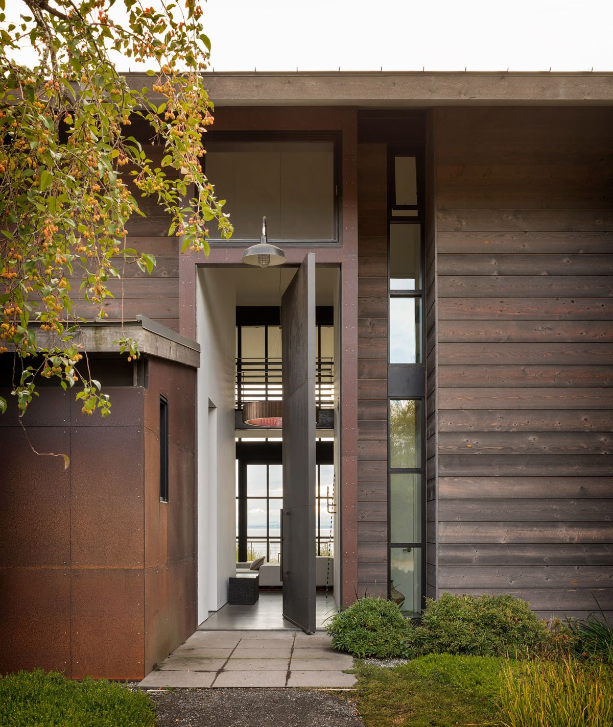 Waterfront home in the Pacific Northwest by Olson Kundig large pivot door