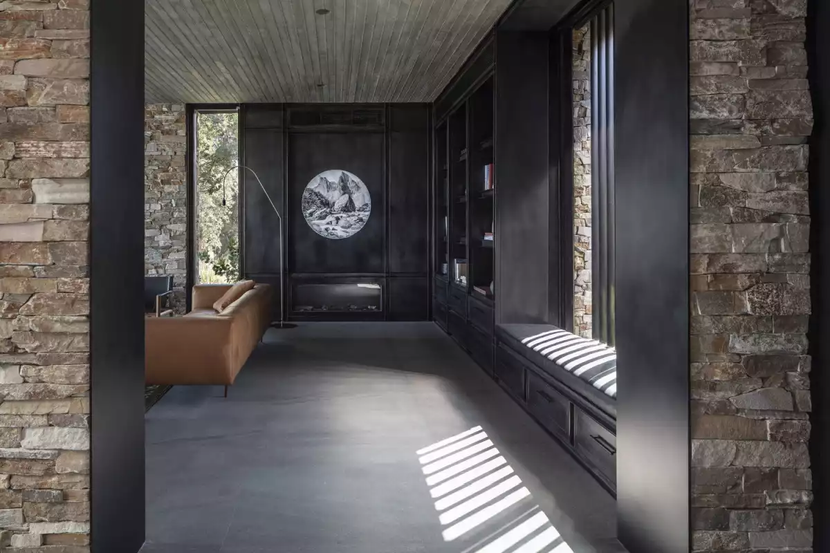 The dark and muted colors of the interior design complement the stone walls