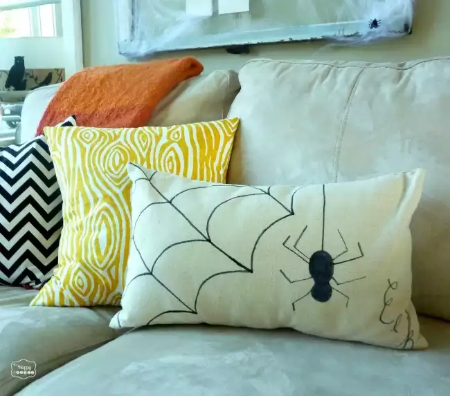 Draw a spider web and a spider on a pillow