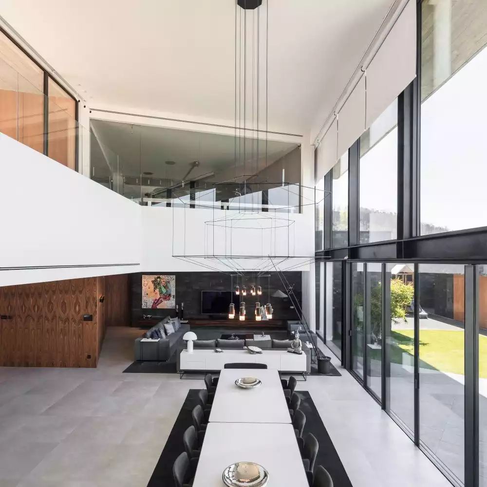 At the core of the house stands a double-height volume with a gorgeous, low-hanging chandelier