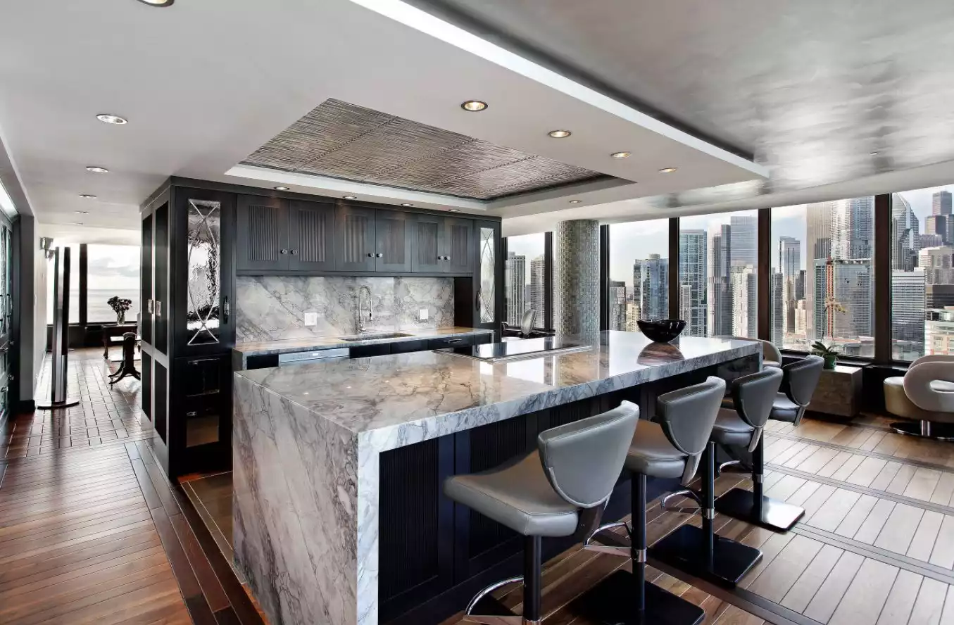 Kitchen with gray marble accents and waterfall countertop for bar island