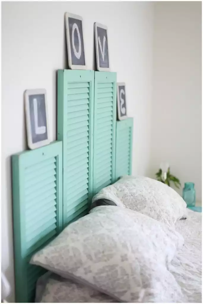 Old turquoise painted window shutters used like headboard