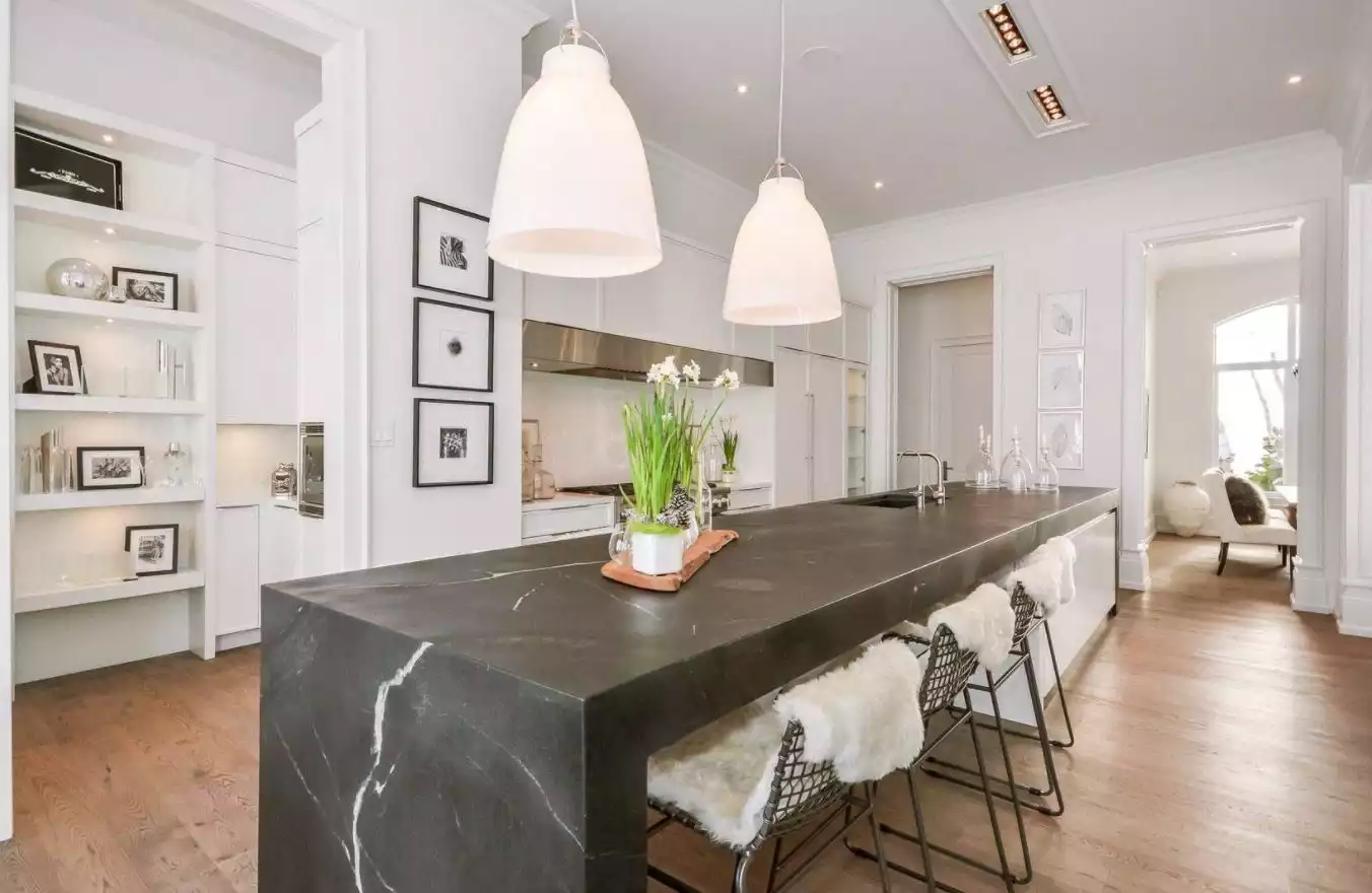 Open space kitchen with black marble waterfall island