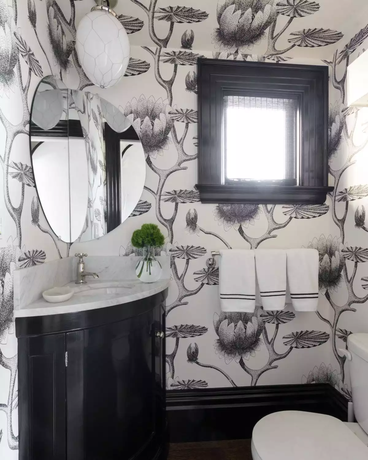 Powder room with black and white wallpaper and corner vanity