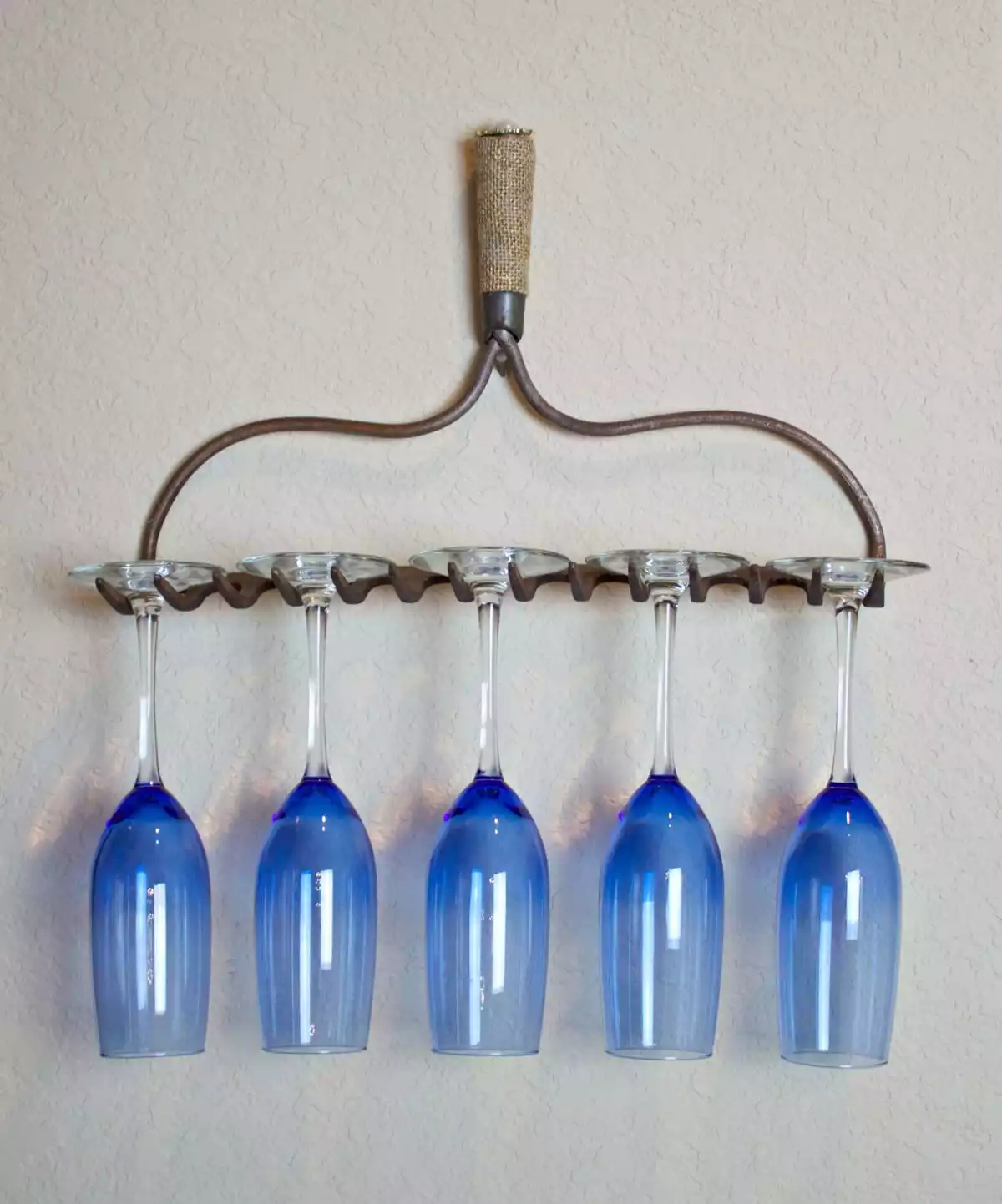 An old garden rake turned into a wine glass holder