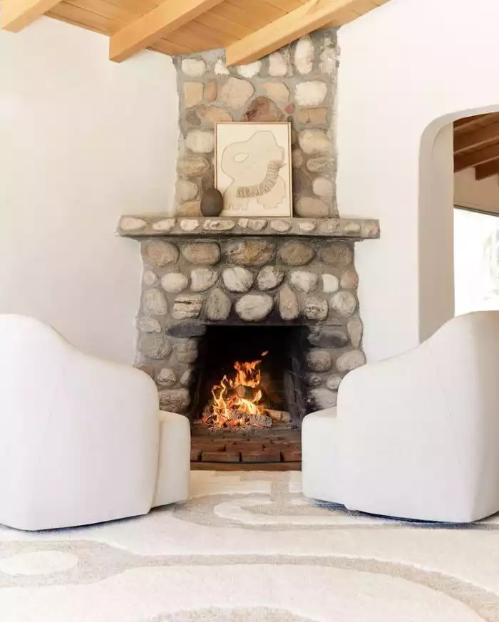 Stone Fireplace with two white armchairs