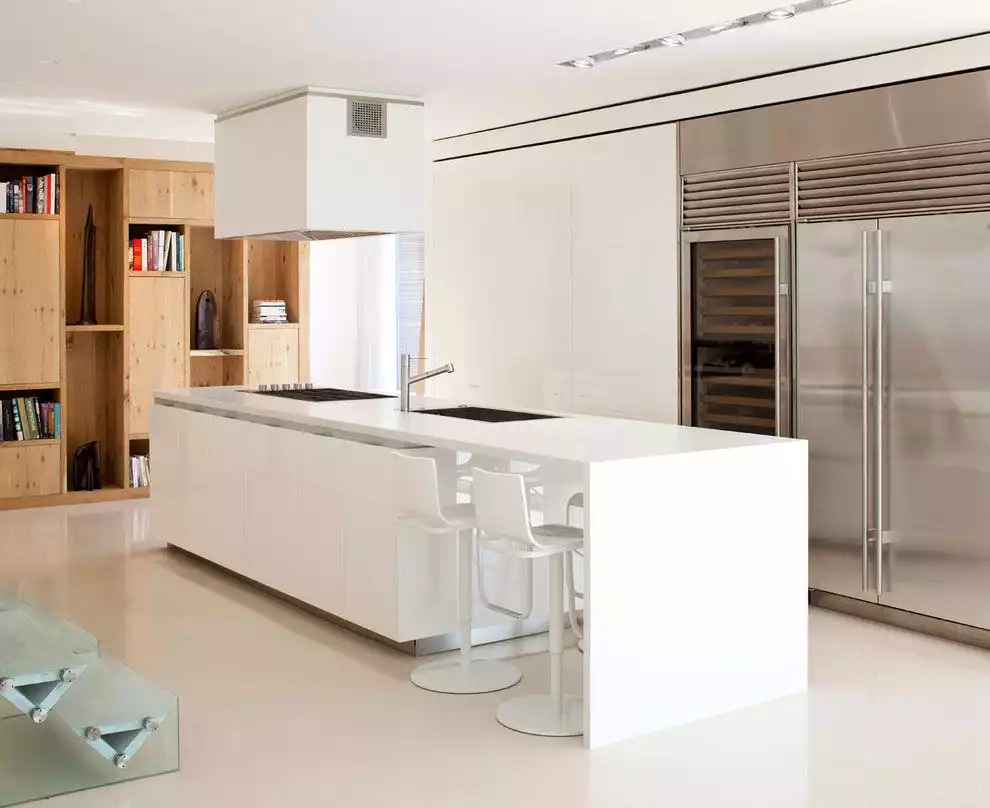 White kitchen island with bar area and induction cooktop