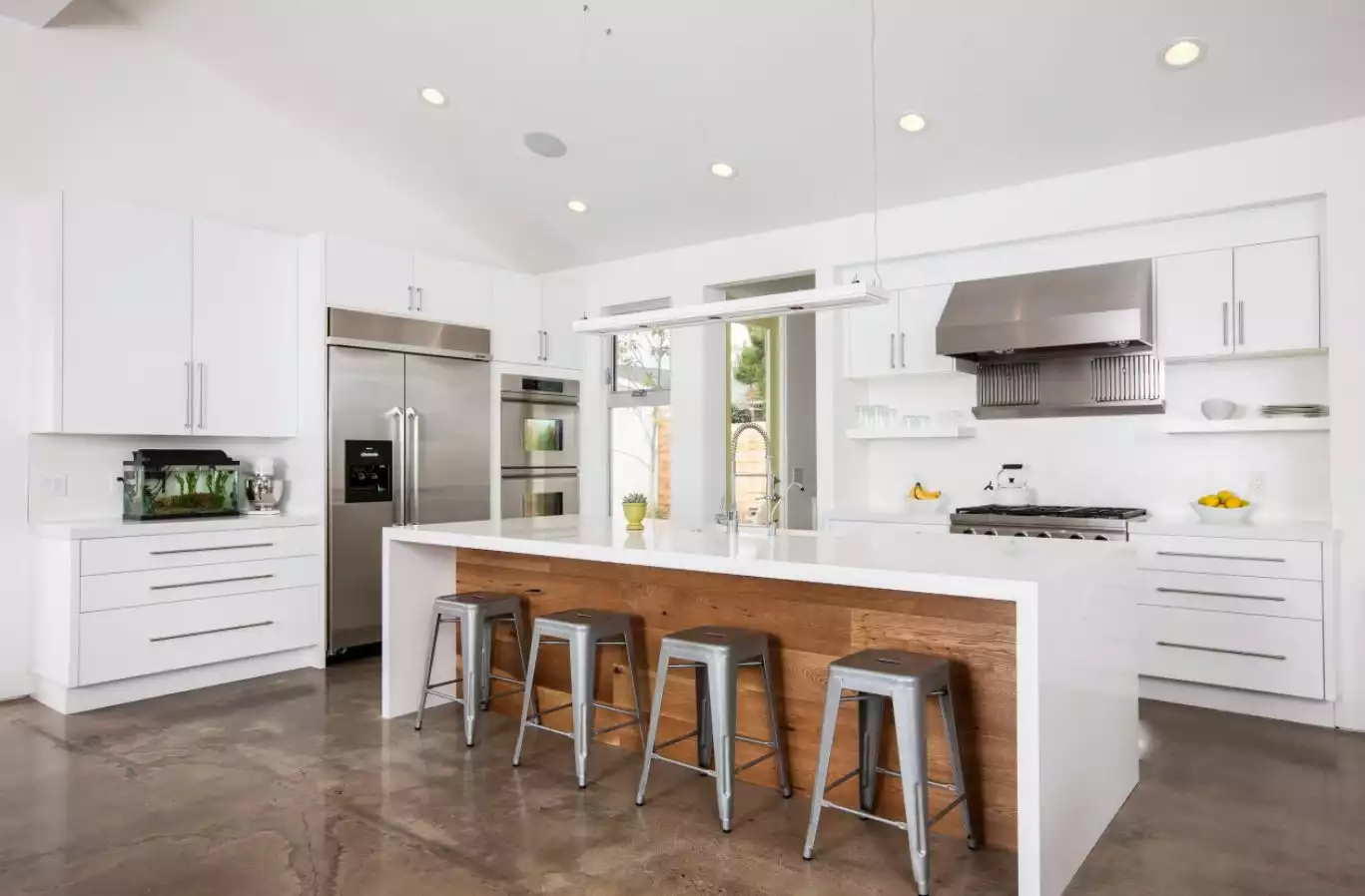 White kitchen with waterfall countertop for island and cement floor