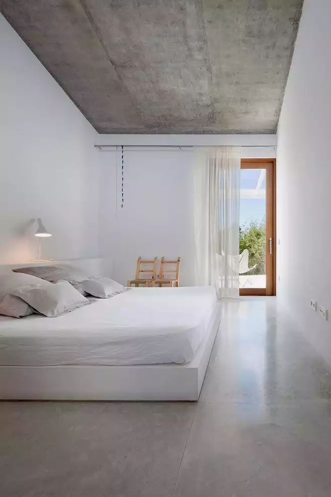 Bedroom with concrete ceiling and polished floor