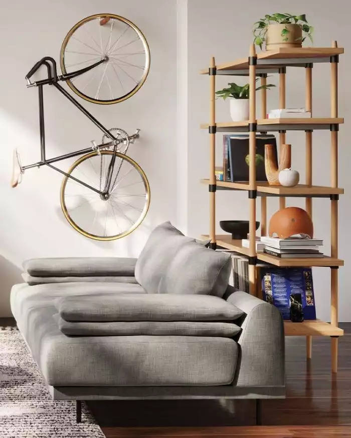 room with gray sofa and bicycle on the wall